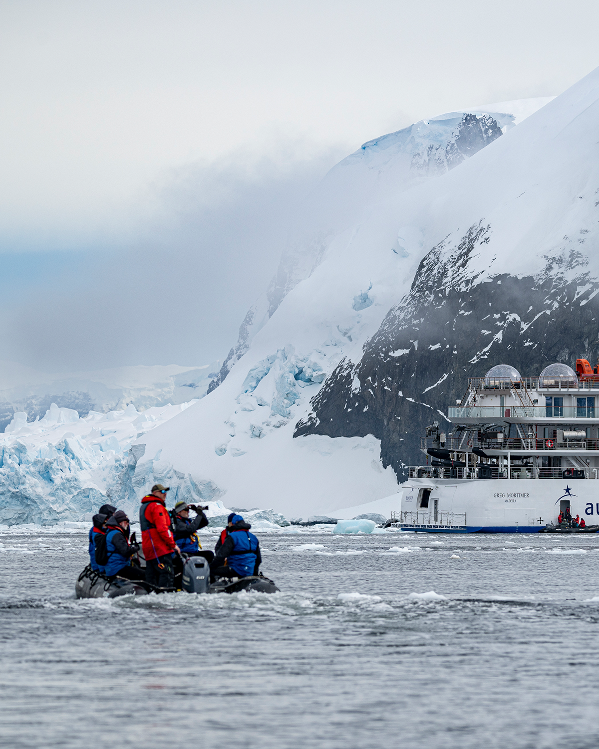 a Zodiac filled with passengers approaching the Greg Mortimer