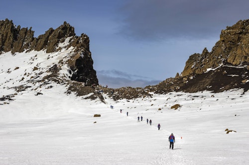 Passengers walking down from Neptunes Window, Deception Island, Richard I'Anson